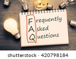 FAQ ( frequently asked questions ) text on notebook with many light bulbs