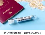 COVID-19, travel and test concept, tube for PCR testing and tourist passport on geographic map. Coronavirus PCR diagnostics in airport due to pandemic. Tourism and business hit by corona virus.
