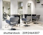 Small photo of Barbershop interior, modern hair beauty salon after renovation. Inside empty barber shop with mirror wall and leather chairs. Clean work places in luxury trendy hairdressing room. Moscow - Sep 2, 2021