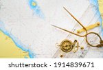 Small photo of Retro styled golden compass (sundial), antique vintage W HC 6" brass dividers calipers nautical navigation chart tool, parallel ruler, old white map close-up. Vintage still life. Sailing accessories