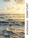 Small photo of Baltic sea shore after the storm. Sunset, soft golden sunlight, glowing clouds. Picturesque panoramic scenery. Nature, environment, ecology, ecotourism, hiking, exploring concepts