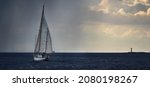 Small photo of Old expensive vintage two-masted sailboat (yawl) close-up, sailing in an open sea during the storm. Dramatic sky, dark clouds. Sport, regatta, recreation, transportation. Panoramic view, seascape