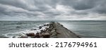 Small photo of Dark storm clouds above the Baltic sea. Kiel, Germany. Rocks, waves and water splashes close-up. A view from the pier. Fickle weather, climate themes. Nature, tourism, cruise, recreation