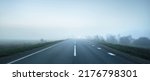 Small photo of Panoramic view of the empty highway through the fields in a fog at night. Moonlight, clear sky. Sunrise. Europe. Transportation, logistics, travel, road trip, freedom, driving. Rural scene