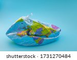 Global warming, climate catastrophe and environmental trouble concept with deflated globe isolated on blue background
