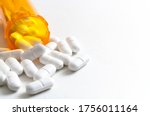 Small photo of Opioid epidemic, drug abuse and overdose concept with scattered prescription opioids spilling from orange bottle with copy space. Hydrocodone is the generic name for a range of opiate painkillers