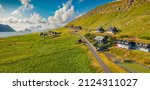 Sunny summer view from flying droneof Kirkjubour village with Hestur Island on background. Panoramic morning scene of Faroe Islands, Denmark, Europe.  Beauty of nature concept background.
