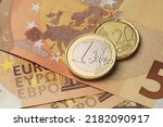 One euro and twenty cents coins on the red fifty paper bills.