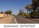 Small photo of Narrow unmarked designated bike lane separated from main road part by a wide white line along North 37th Avenue in residential area on North-West Phoenix, Arizona