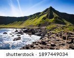 Small photo of Landscape of Giant's Causeway trail with a blue sky in summer in Northern Ireland, County Antrim. UNESCO heritage. It is an area of basalt columns, the result of an ancient volcanic fissure eruption