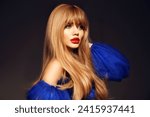 Beautiful perfect long hairstyle. Beauty makeup. Girl model portrait with red lips and wavy hair style isolated on black studio background. Profile face.