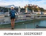 Woman westerner travel in backpack with map looking at city view of Castle SalzburgCity in Austria