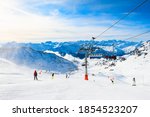Ski resort in winter Alps. Skiers ride down the slope. Val Thorens, 3 Valleys, France. Beautiful mountains and the blue sky, winter landscape