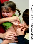 Small photo of TAIPA, NZL - MAY 16 2014:Small girl (Talya Ben Ari age 4) receives an immunization of DPT and MMR vaccine. New vaccines could avert nearly 4 million deaths of children under the age 5 by 2015.