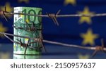 Small photo of European Union currency wrapped in barbed wire against flag of EU as symbol of Economic warfare, sanctions and embargo busting. Horizontal image. Copy space.