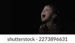 Small photo of Conceptual image: pain in children. Psychological portrait of nervous and overexcited young girl screams and wants to tear the t-shirt. Copy space.