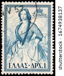 Small photo of LUGA, RUSSIA - OCTOBER 15, 2019: A stamp printed by GREECE shows Queen Consort of Greece Amalia wearing romantic folksy court dress, still known as the Amalia dress, circa 1956.