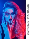 Small photo of Close-up of a rock star girl with bright glitter makeup and hair in glam rock style in colored stage lighting. Rock accessories. Rock and Pop music.