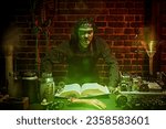 Small photo of Horror thriller movie. A medieval alchemist is looking for the elixir of youth. An ugly man with scars on his face - an obsessed scientist works in his laboratory with old manuscripts. Halloween.