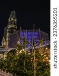 Small photo of BERLIN, GERMANY - January 1, 2022: New Year's Eve night view of Kaiser Wilhelm Memorial Church (1906) with broken spire and modern New church and belfry (1963) on Breitscheidplatz.