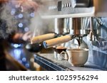 Barista making a espresso with a classic Italian coffee machine with steam in background.