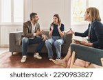 Small photo of Couple Arguing During Marriage Counseling - Married couple heatedly arguing on a couch during family therapy. The woman looks frustrated, while the man appears aggressive. Psychologist mediates.