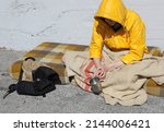 Small photo of beggar sitting on a filthy mattress in the street asking for charity and alms