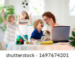 Small photo of Mother working from home with kids. Homeschooling and home office. Quarantine, closed school, coronavirus outbreak. Self isolation and social distancing. Children make noise and disturb mom at work.