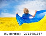 Pray for Ukraine. Child with Ukrainian flag. Little blond boy waving national flag praying for peace. Happy kid celebrating Independence Day.
