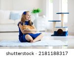Child Playing With Cat At Home. ...