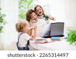 Small photo of Mother working from home with kids on summer holiday. Children make noise and disturb woman at work. Homeschooling and freelance job. Boy and girl playing making loud noise.