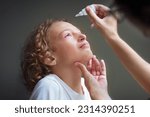 Small photo of Child with swollen pink eye. Eyes infection and pollen allergy. Allergic little boy with runny nose and red eyes. Sick kid at doctor or hospital.