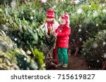 Family selecting Christmas tree. Kids choosing freshly cut Norway Xmas tree at outdoor lot. Children buying gifts at winter fair. Boy and girl shopping for Christmas decoration at market. Holiday time
