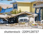 Small photo of Fort Myers, FL, USA - October 1, 2022: Truck pinned down under storm debris Hurricane Ian Fort Myers FL