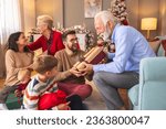 Happy multi-generation family gathered at home on Christmas day, exchanging Christmas presents and enjoying spending time together during winter holiday season