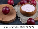 flavored pink yogurt with ripe and sweet plum, preparation of dairy products with aroma and pieces of red plum