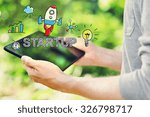 Startup concept with young man holding his tablet computer outside in the park