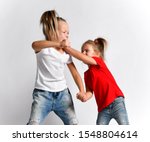 Small photo of Two girls friends, sisters in jeans and t-shirts are fighting, crying hurt each other, abuse. Younger hits fight back elder. Bad attitudes, family conflict, human relations concept