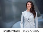 Smiling beautiful commercial model business woman professional entrepreneur in a suit with copy space