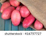 red potatoes in burlap sack on a blue wooden table