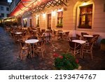 tables and chairs of a street restaurant in evening Lviv