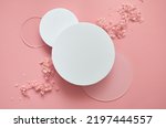 Small photo of White round podium pedestal cosmetic beauty product presentation scene empty mockup on trendy pink coral pastel background with spring flowers, minimalist flat lay backdrop luxury template, top view.