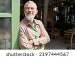 Small photo of Happy smiling confident european middle aged older adult man small local business owner standing outside own cafe looking away and dreaming. Old senior entrepreneur portrait. Entrepreneurship