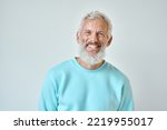 Small photo of Happy mature old bearded man with dental smile, cool mid aged gray haired older senior hipster wearing blue sweatshirt standing isolated on white background looking at camera, headshot portrait.