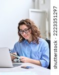 Small photo of Young business woman, female online teacher looking at laptop having hybrid conference online remote video call, virtual distance class or watching webinar training presentation working in office.