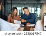 Professional executives business group working with documents at meeting in office. Smiling corporate board team having discussion planning company project strategy sitting at board room table.