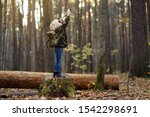 Small photo of Little boy scout with spyglass during hiking in autumn forest. Child is looking through a spyglass. Concepts of adventure, scouting and hiking tourism for kids.