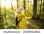 Small photo of Little boy scout with binoculars during hiking in autumn forest. Child is looking with binoculars. Concepts of adventure, scouting and hiking tourism for kids. Exploring nature