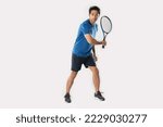 Small photo of Male tennis player playing tennis with striving for victory gesture on white background.