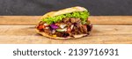 Small photo of Doner Kebab Doner Kebap fast food in flatbread on a wooden board panorama snack